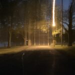 a photo of a path at white rock lake park in dallas, texas. the camera was jerked down as the shutter closed, resulting in light trails cascading down from the top of the frame.